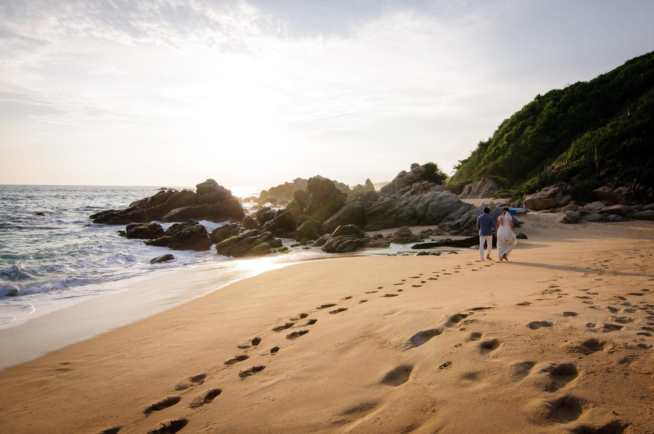 Playa virgen y solitaria en la costa de Oaxaca con palmeras y arena dorada.